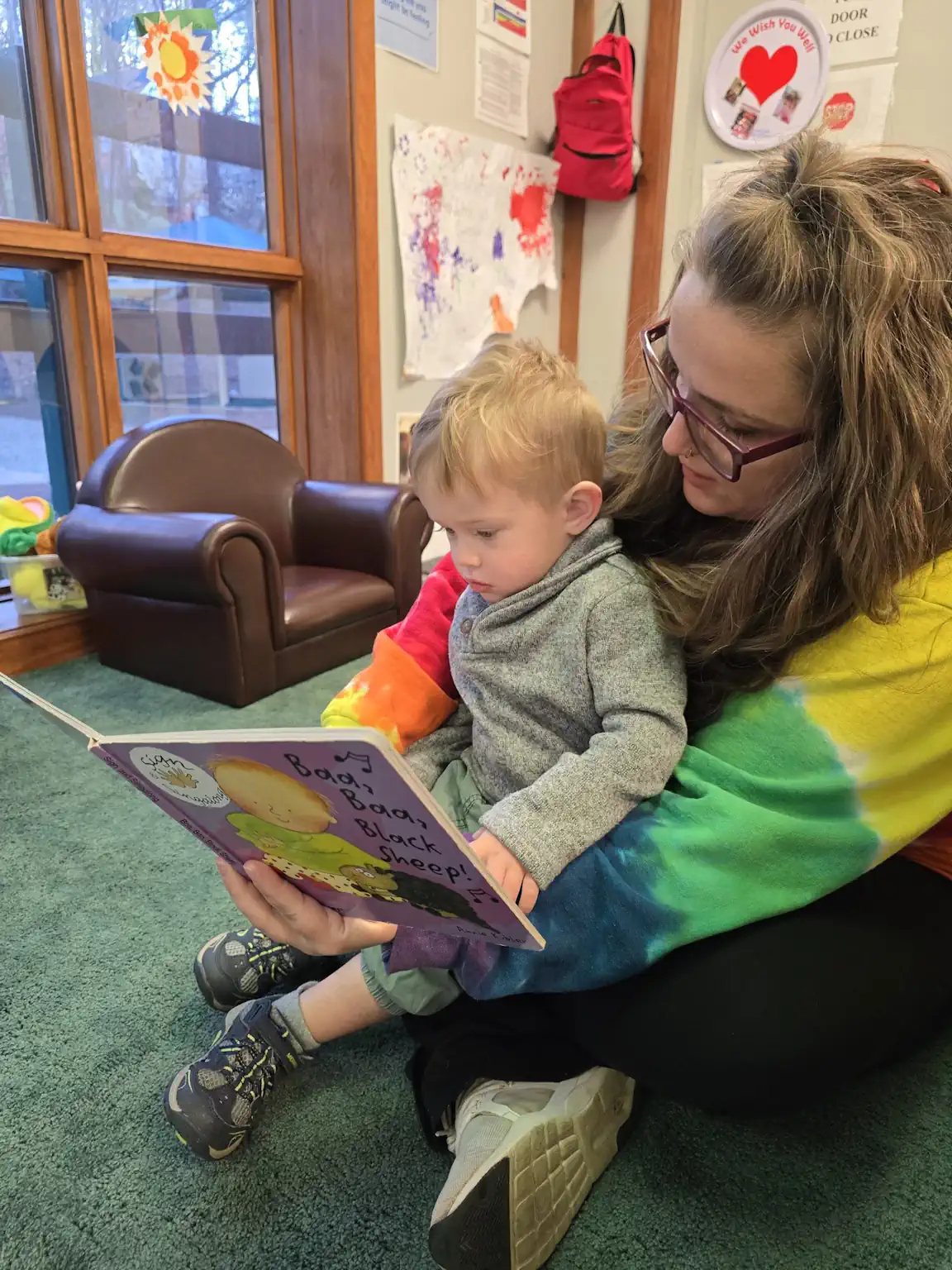instructor reading with child in the nursery