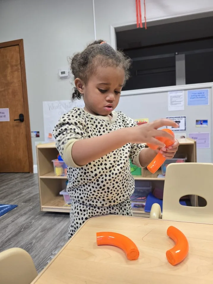 child playing with shapes on the table in nursery room in Tyron, NC