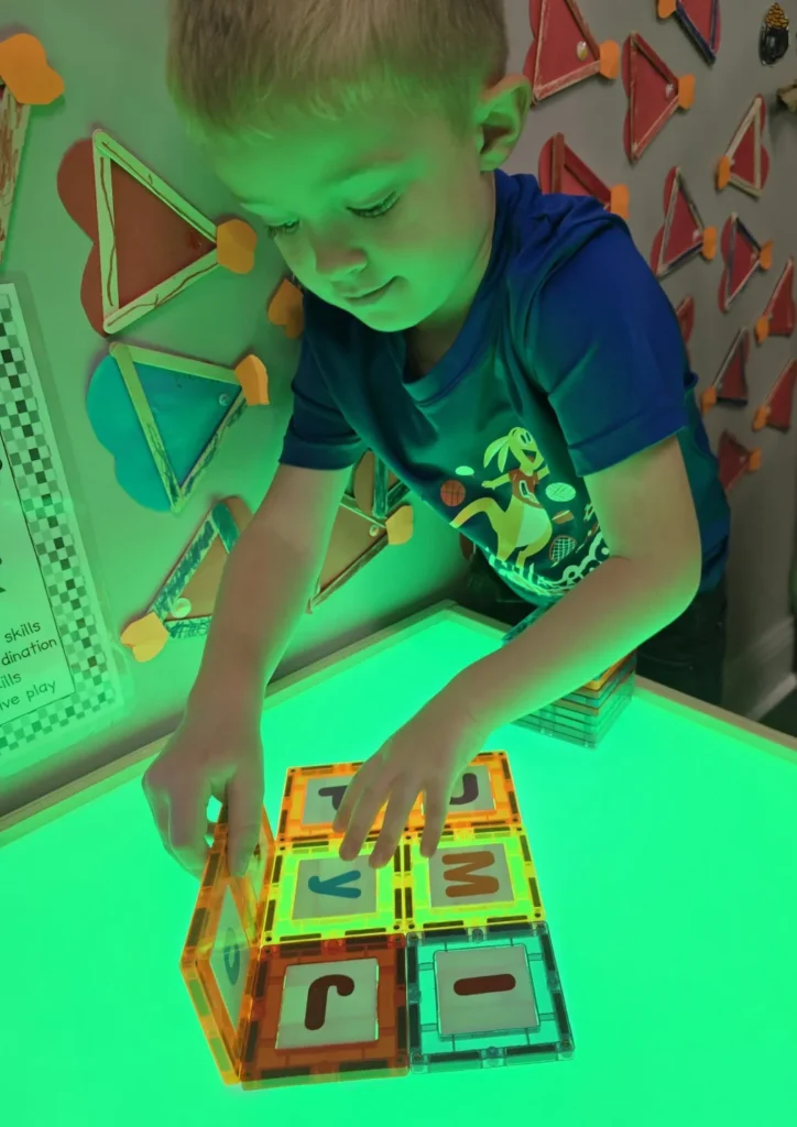 child playing with alphabet tiles in Redland, SC