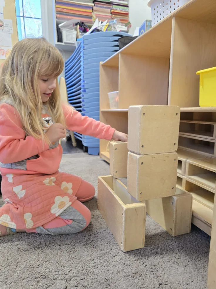 child wearing pink outfit while with wooden blocks in Redland, SC