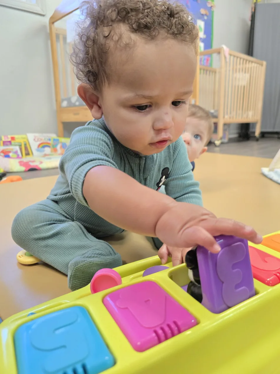 a child playing with a colorful box of toys
