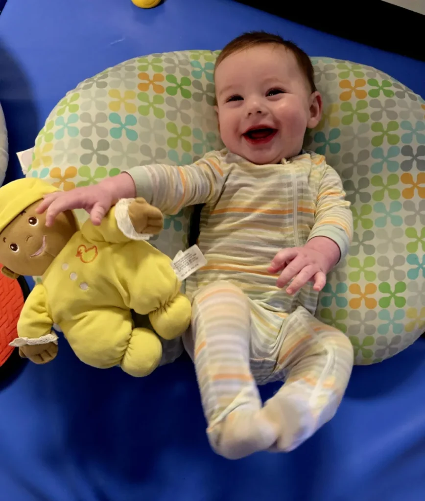 A baby in striped pajamas peacefully resting on a pillow at a child daycare center in Boiling Springs, SC